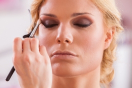 Beautiful woman doing make-up with eyeliner on eye